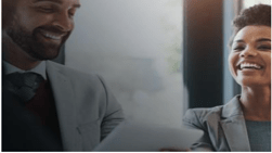 Stock photo of two co-workers laughing.